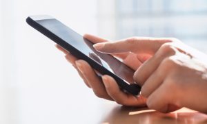 Imagem de um celular na mão de um usuário